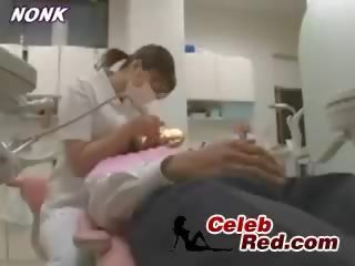 اليابانية طبيبة الاسنان ممرضة يعطي وظيفة اليد إلى المريض